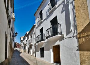 - un bâtiment blanc avec balcon dans une rue dans l'établissement CASA VALDES 16, APTO 3, à Cáceres