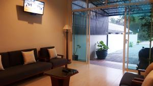 a living room with a couch and a sliding glass door at Baramate Khao Lak - SHA PLUS in Khao Lak