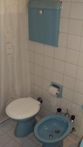 La salle de bains est pourvue de toilettes bleues et d'un lavabo. dans l'établissement Hotel Aries Palermo, à Buenos Aires