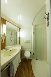 a bathroom with a toilet, sink, and shower at ibis Chennai Sipcot - An Accor Brand in Chennai