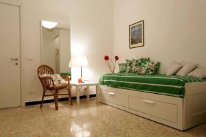 a bedroom with a bed and a chair and a table at Baisi Flexyrent in Rapallo