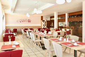 ein Restaurant mit Tischen und Stühlen in einem Raum in der Unterkunft Hotel am Buchwald in Esslingen