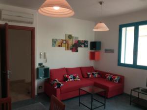 プンタ・セッカにあるCasa Vacanze Kamarinaのリビングルーム(赤いソファ、窓付)