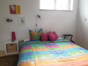 a bed with a colorful comforter in a bedroom at Seegarten #9 in Stadtlauringen