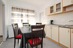 a kitchen and dining room with a table and chairs at Apartment Mihaela in Baška