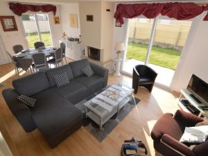 a living room with a couch and a table at Seafront holiday home with garden in Denneville in Denneville