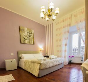 ローマにあるLa Muraglia Di San Pietroのベッドルーム1室(ベッド1台、シャンデリア付)
