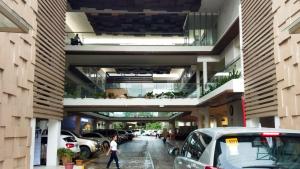 a building with cars parked in a parking lot at Cozy Place at Bamboo Bay Cebu in Cebu City