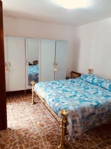 a bedroom with a bed with a blue comforter at Casotti in Cutigliano