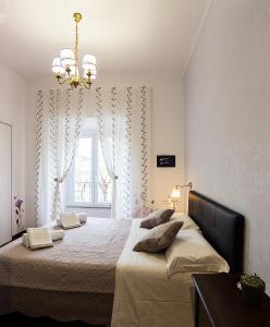 una camera da letto con un letto con un lampadario a braccio e una finestra di La Muraglia Di San Pietro a Roma