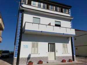 a white building with stairs on the side at B&b la finestra sul mare in Capo dʼOrlando