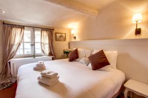 een slaapkamer met een groot wit bed en handdoeken bij Les Quatre Dauphins in Aix-en-Provence