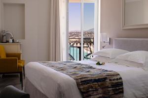 a bedroom with a bed with a view of a balcony at Hotel Suisse in Nice