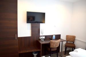 a hotel room with a desk and a tv on a wall at Trip Inn Budget Hotel Messe in Frankfurt