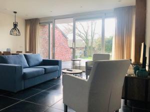 a living room with a blue couch and chairs at Vakantie Appartementen De Bonte Kraai in Raamsdonk
