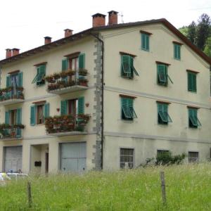 un edificio bianco con persiane e finestre verdi di Casotti a Cutigliano