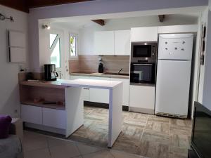 Il comprend une cuisine équipée d'une table blanche et d'un réfrigérateur. dans l'établissement Villa au calme à 200m de la plage de Rochelongue, au Cap d'Agde