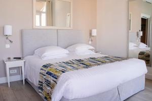 a bedroom with a large bed and a mirror at Hotel Suisse in Nice