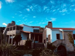 una casa con un cielo azul en el fondo en Finca Briabí en La Cañiza