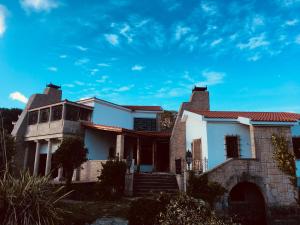 uma casa com um céu azul ao fundo em Finca Briabí em La Cañiza