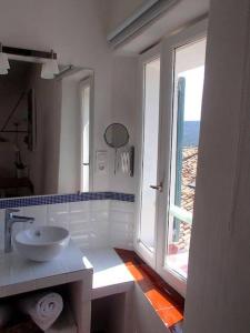 a white bathroom with a sink and a window at Le 1835, Studio Bleu-Coton in Moustiers-Sainte-Marie