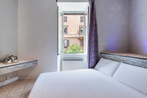 um quarto com uma cama branca e uma janela em SmooRoomS Ostiense em Roma