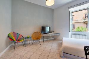 a living room with two chairs and a television at SmooRoomS Roma Ostiense in Rome