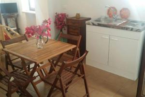 a kitchen with a table and chairs with a vase of flowers at A Kasuzza in Pantelleria