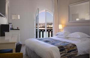 a bedroom with a bed with a view of a balcony at Hotel Suisse in Nice