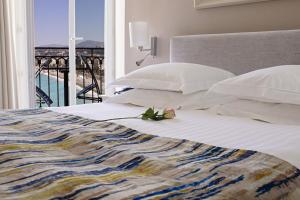 a bedroom with a bed with a view of the ocean at Hotel Suisse in Nice