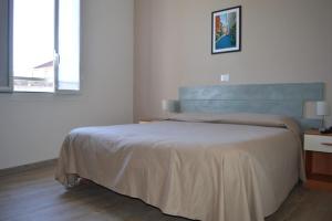 um quarto com uma cama grande e uma janela em Hotel La Tavernetta em Varazze
