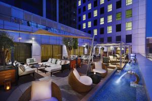 patio z basenem, stołami i krzesłami w obiekcie Park Mall Hotel & Conference Center w Satif
