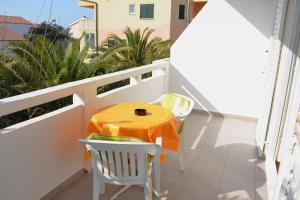 a small balcony with a table and chairs on it at Apartments Mike in Novalja