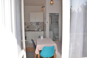 a small kitchen with a table and blue chairs at Apartments Mike in Novalja +50 photos