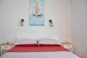 a bedroom with a white bed with two red pillows at Apartments Mike in Novalja