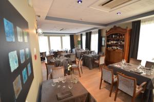 a restaurant with tables and chairs in a room at Logis Hôtel Le Saint Georges in Vivonne