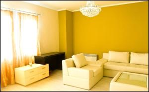 a living room with a couch and a chandelier at Hotel Leder in Kočani