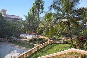 a view from the balcony of a resort with palm trees at Rendezvous Beach Resort Panjim in Dona Paula