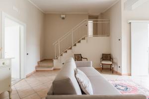 a living room with a couch and a staircase at Casa dei Sogni - Exclusive Suite in Villa in Lido di Ostia