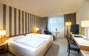Uma cama ou camas num quarto em Maritim Hotel Stuttgart