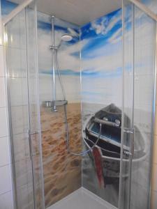 a bathroom with a shower with a painting of a boat at Neues Vaterland in Zehdenick