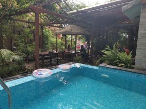 a swimming pool in a backyard with a pergola at Hotel Middle Path & Spa in Pokhara