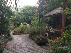 a group of people sitting at a table in a garden at Hotel Middle Path & Spa in Pokhara