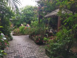 a group of people sitting in a garden with flowers at Hotel Middle Path & Spa in Pokhara