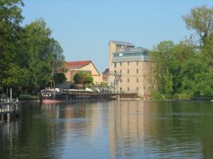 a boat is docked on a river near a building at Neues Vaterland in Zehdenick