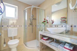 a bathroom with a toilet, sink, tub and shower at Apartments Prpic in Senj