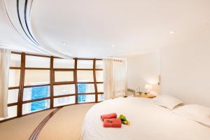 um quarto com uma grande cama branca e uma grande janela em Quai des Marinières AP2015 by Riviera Holiday Homes em Villefranche-sur-Mer