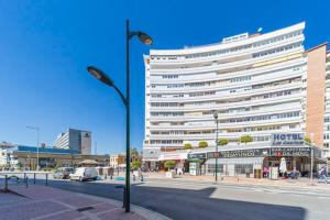 a large white building on a city street with a street light at Hotel Las Américas in Málaga