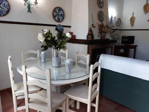 uma mesa com cadeiras e um vaso de flores sobre ela em Chalet la Huerta 2 amplios jardines y WiFi em Conil de la Frontera