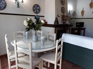 stół z krzesłami i wazon kwiatów na nim w obiekcie Chalet la Huerta 2 amplios jardines barbacoa y WiFi w mieście Conil de la Frontera